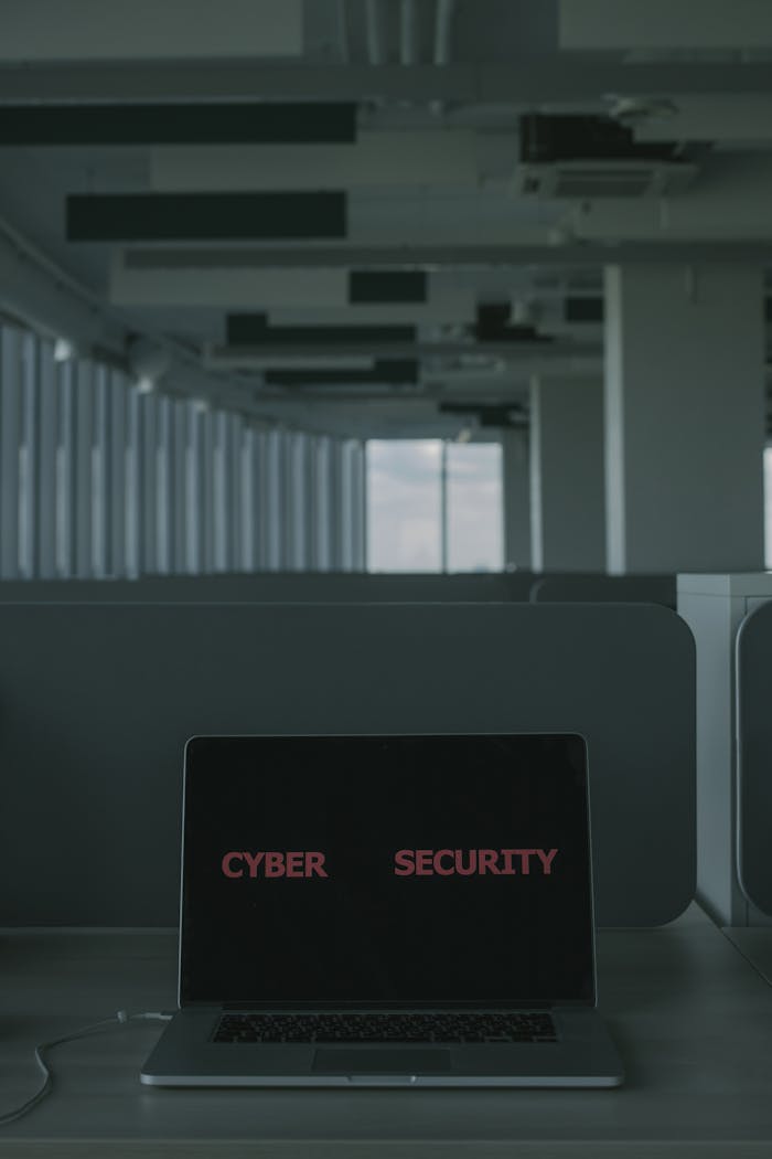 hero-img-02 Laptop displaying 'Cyber Security' in a modern office setting, emphasizing tech and cybersecurity themes.